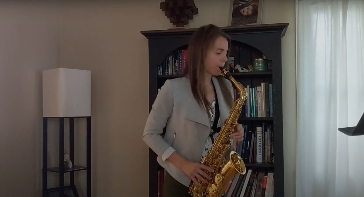 Professor Amanda Heim playing a saxophone in her home