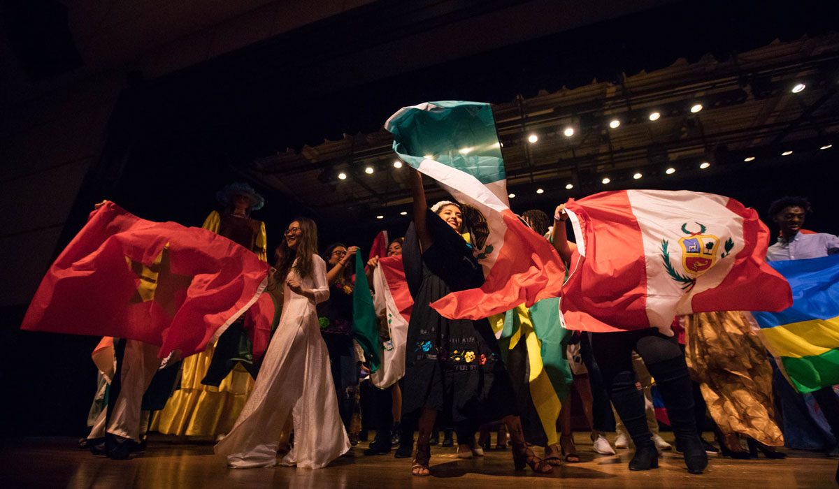 Students wave international flags on stage at BurgBurst