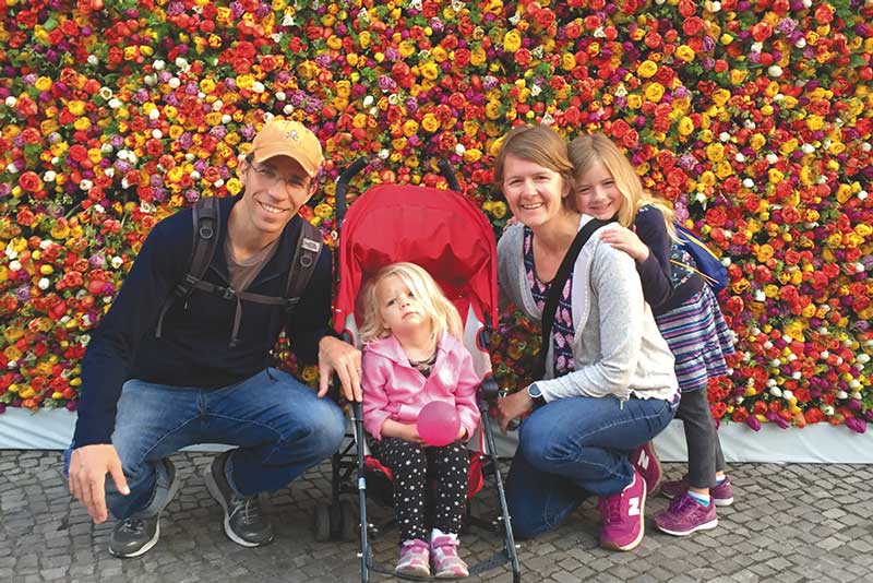 Shelli Frey with her family in front of a colorful wall of tulips