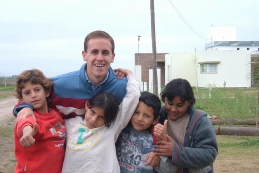 Luke Norris ’06 poses with several children in Argentina