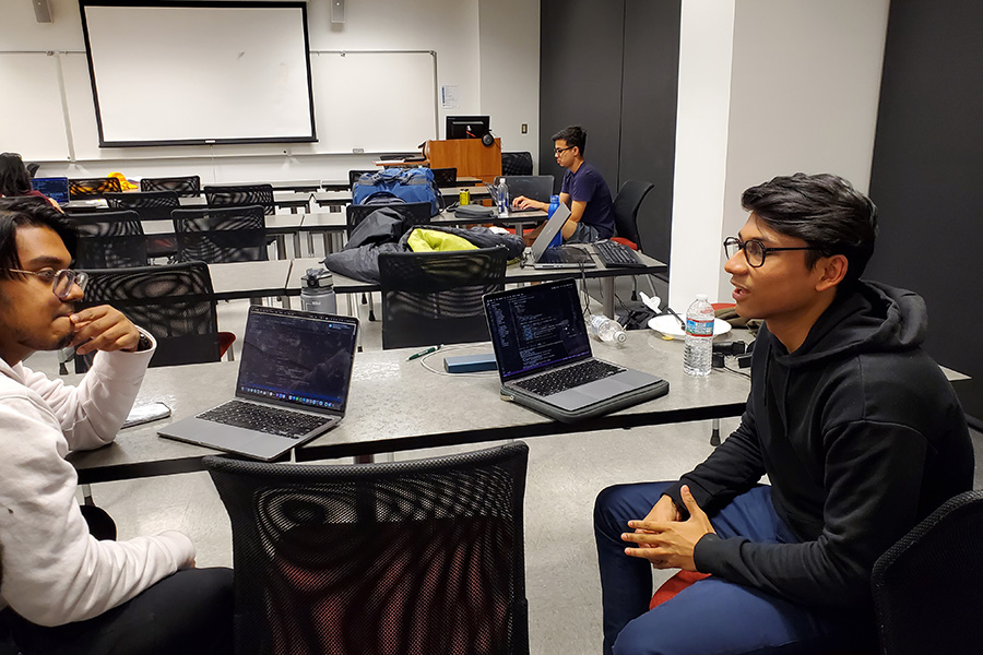 A group of computer science students discuss a programming solution at the YCP 