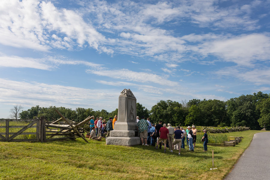 People crowded around a monument on the Gettysburg Battlefield