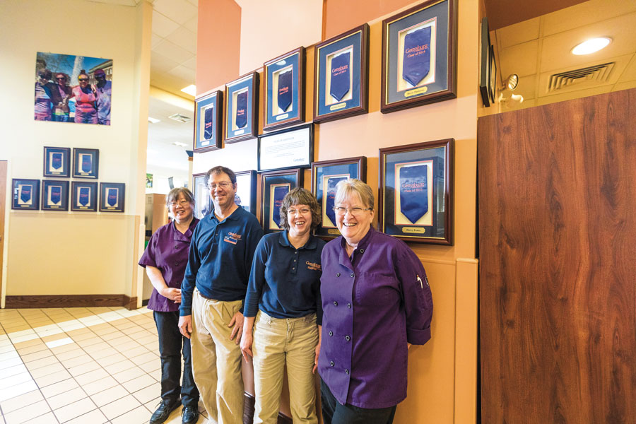 Dining Services employees with stoles of gratitude on the wall