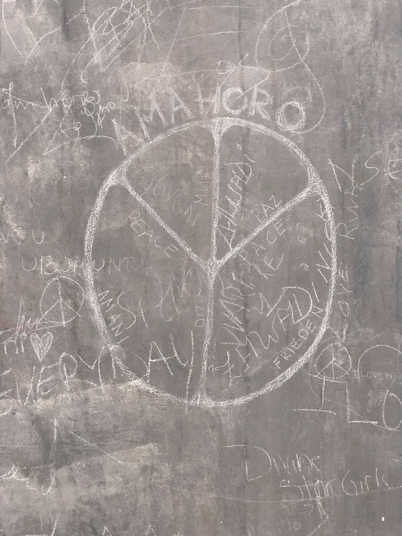 Peace symbol scratched onto a concrete wall