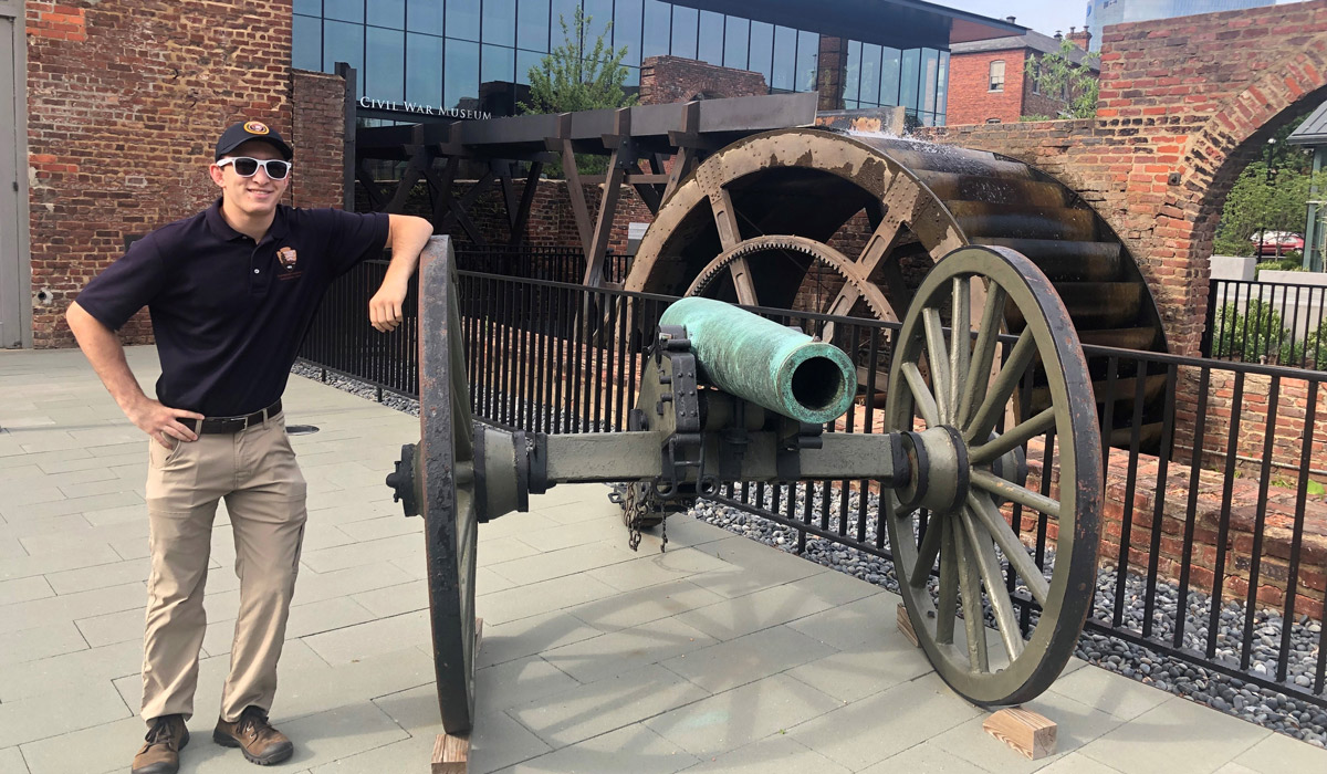 Sean Thompson standing next to a cannon