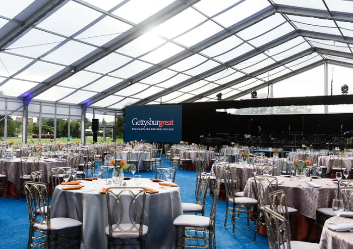 ables set for a Gettysburg College event under a large tent.