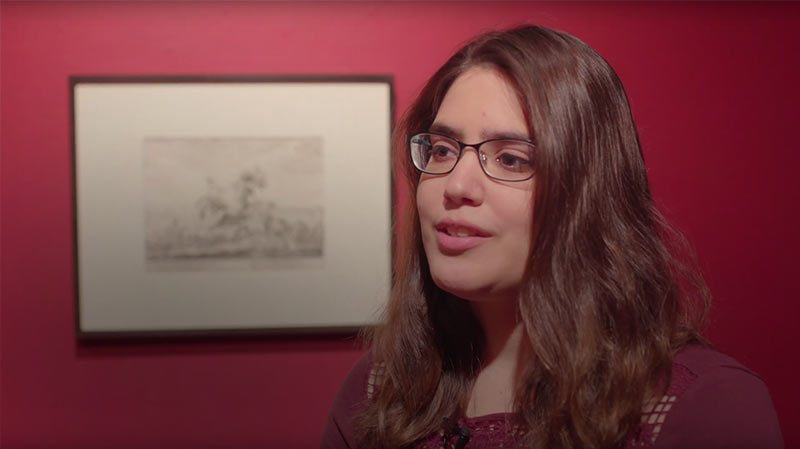 Headshot of Melissa Casale in an art gallery explaining a 17th century print