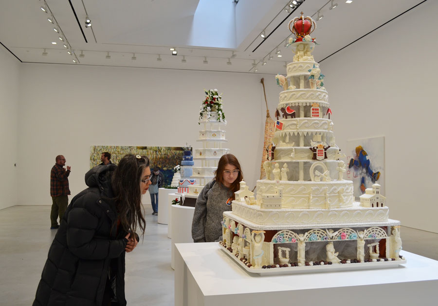 Artwork that resembles a wedding cake with students looking at it