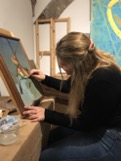 Student painting a picture in the studio