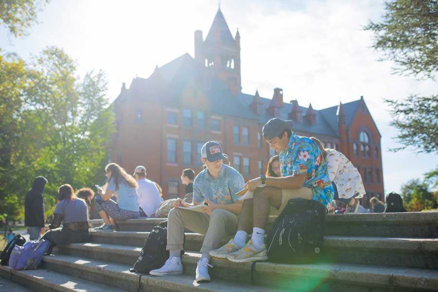 Students sitting and studying on steps outdoors