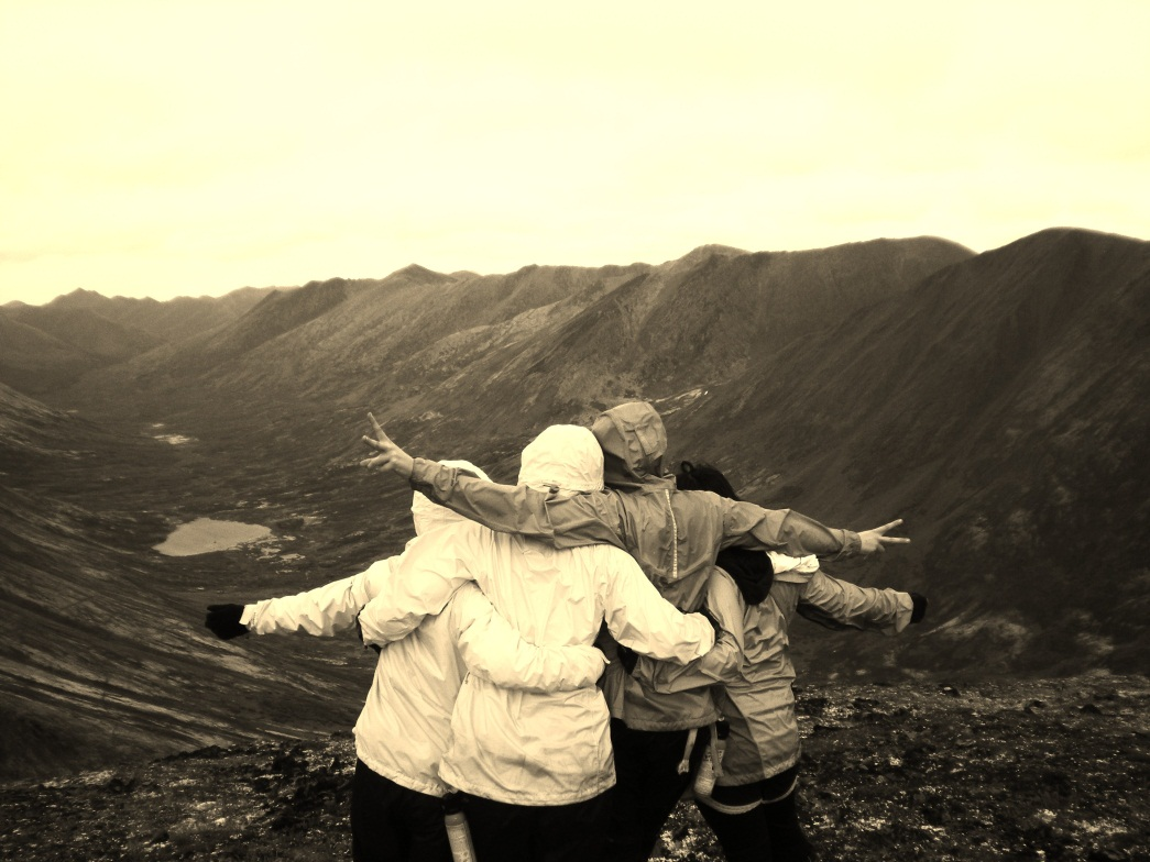 Three people standing on a mountain area