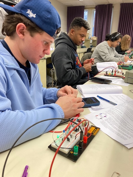 Student assembling a circuit in an electronics lab