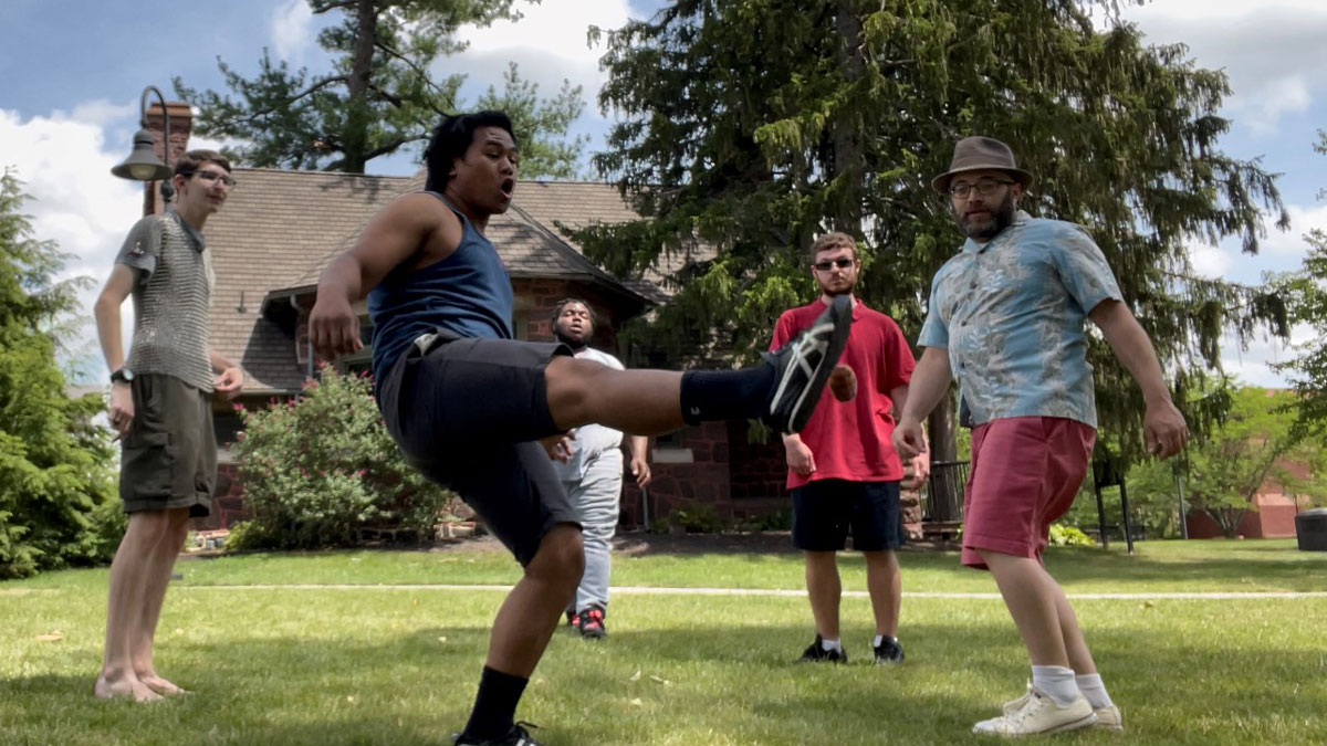Students playing hacky sack outside on the grass