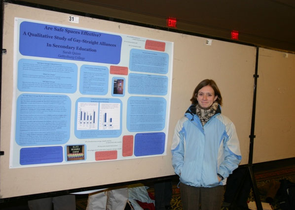 Sarah ’ 05 standing next to her poster