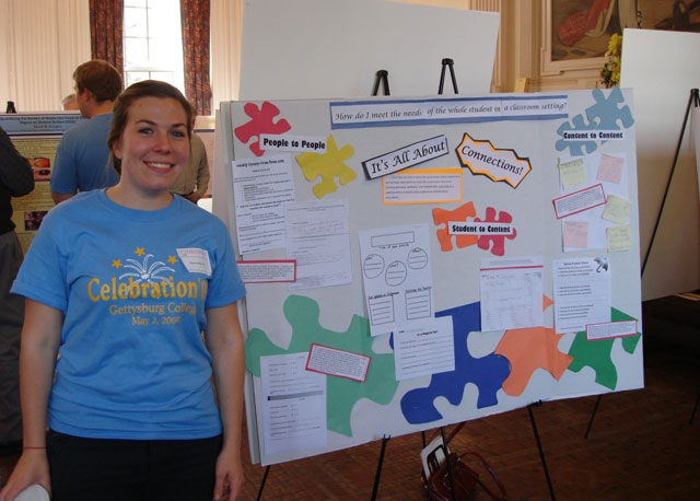 Stacey Cele ’ 09 standing next to her poster