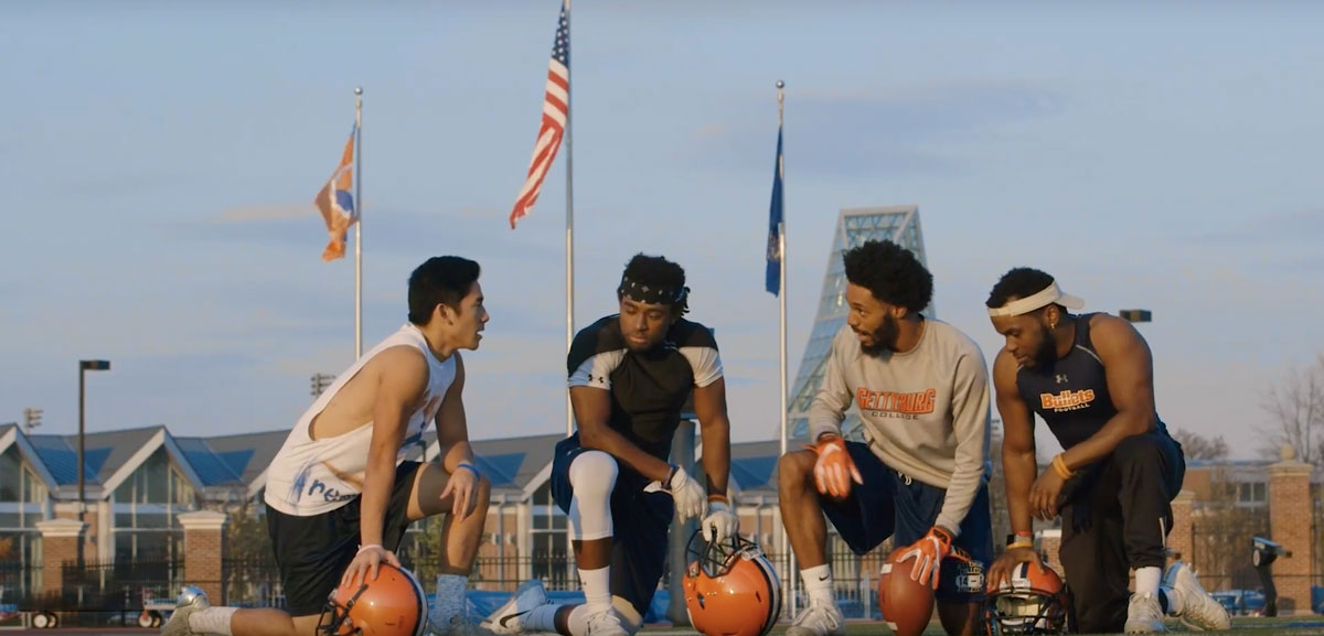 Ty Abdul-Karim 18 and friends kneeling on the field with basketballs in their hands