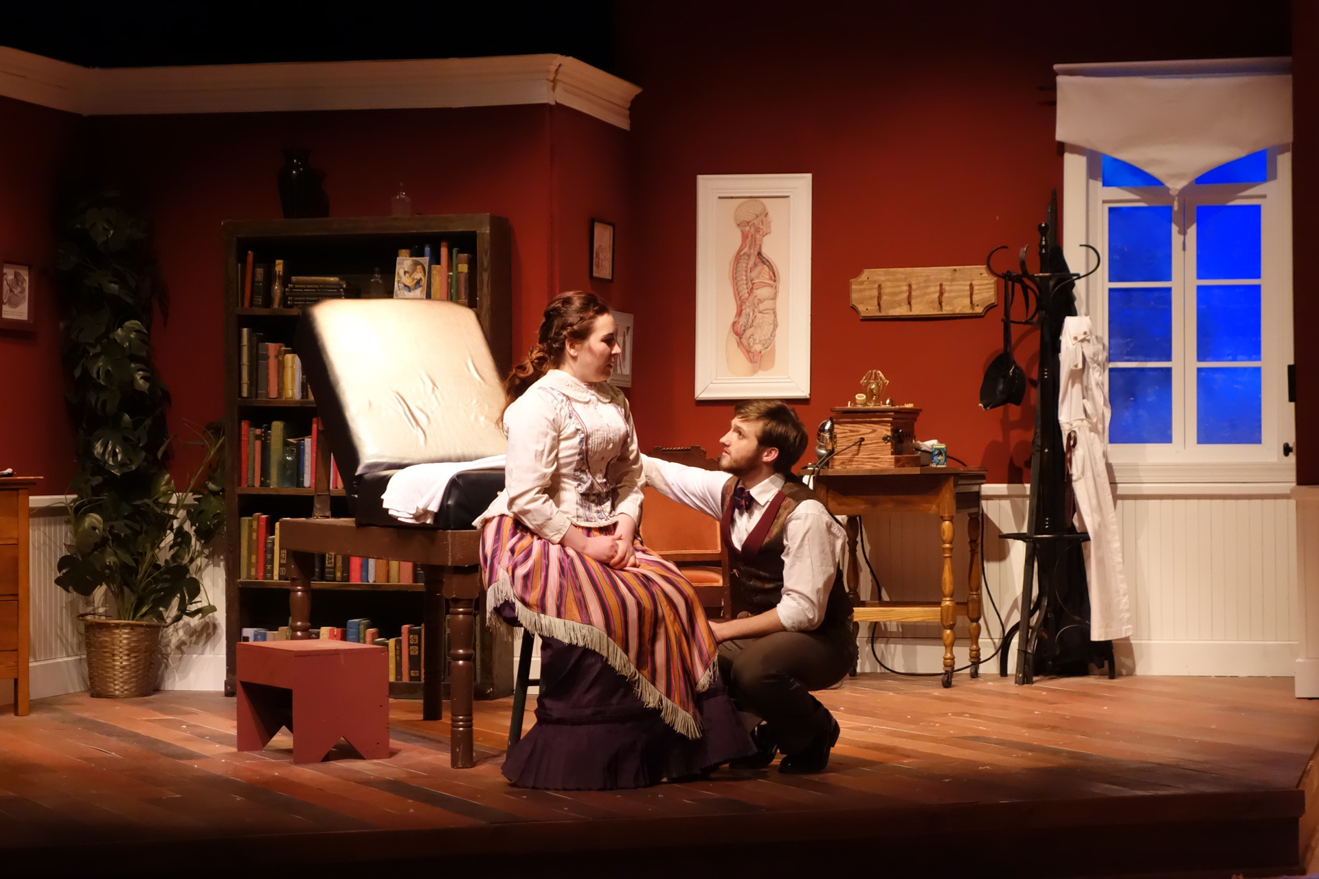 Doctor kneeling in front of a woman on a stool