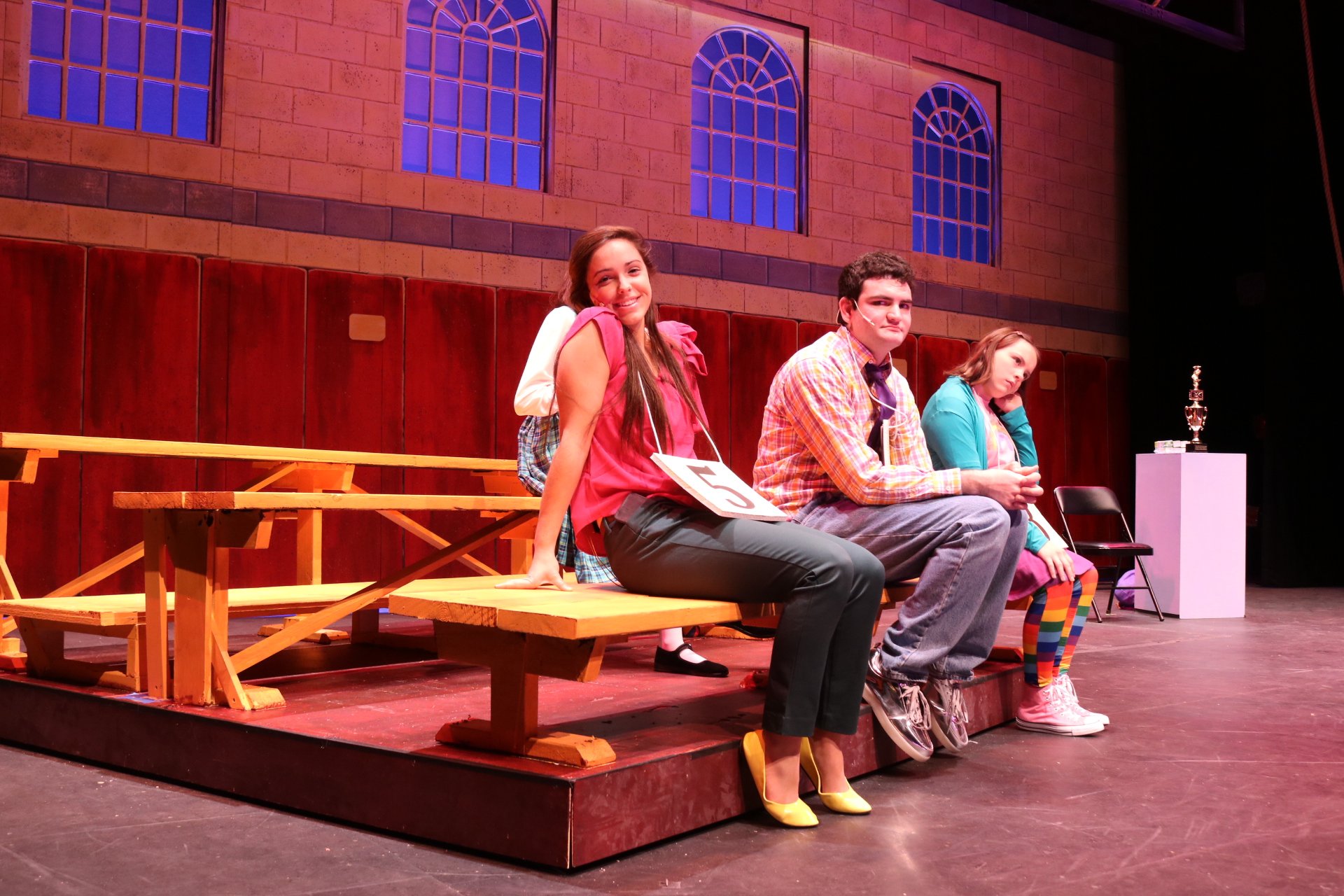 Students sitting on a bench and looking at the camera