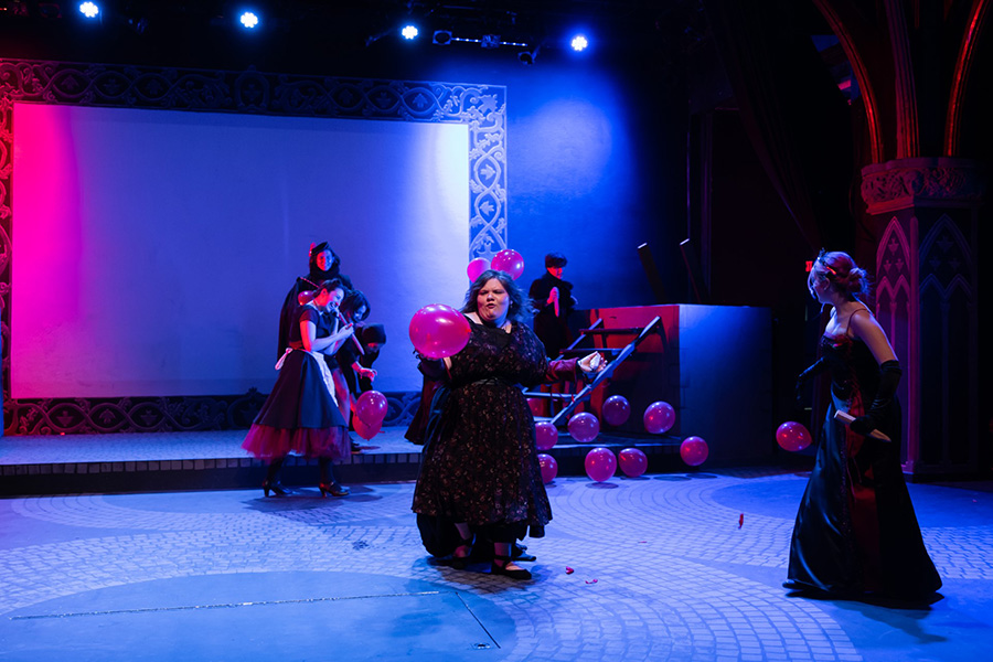 Women holding prop baloons on stage