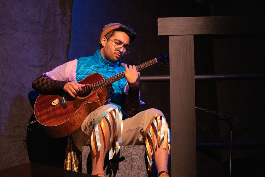 A man sitting and playing guitar