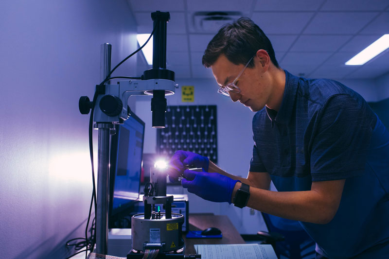 student using microscope in classroom