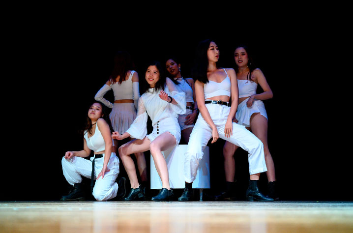 Group of students dancing on stage at a campus event