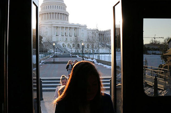 Student opening bus door in front of US Capitol building
