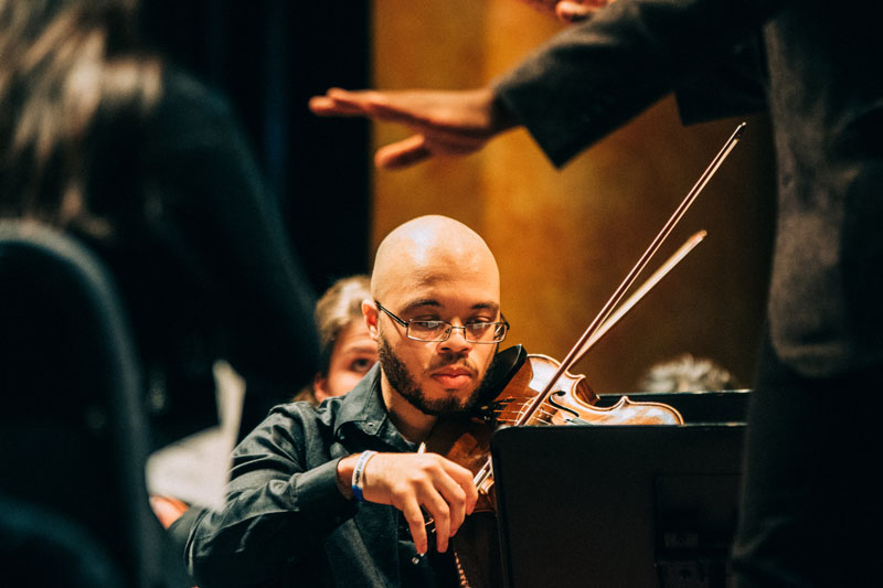 Student playing the violin in the Sunderman orchestra