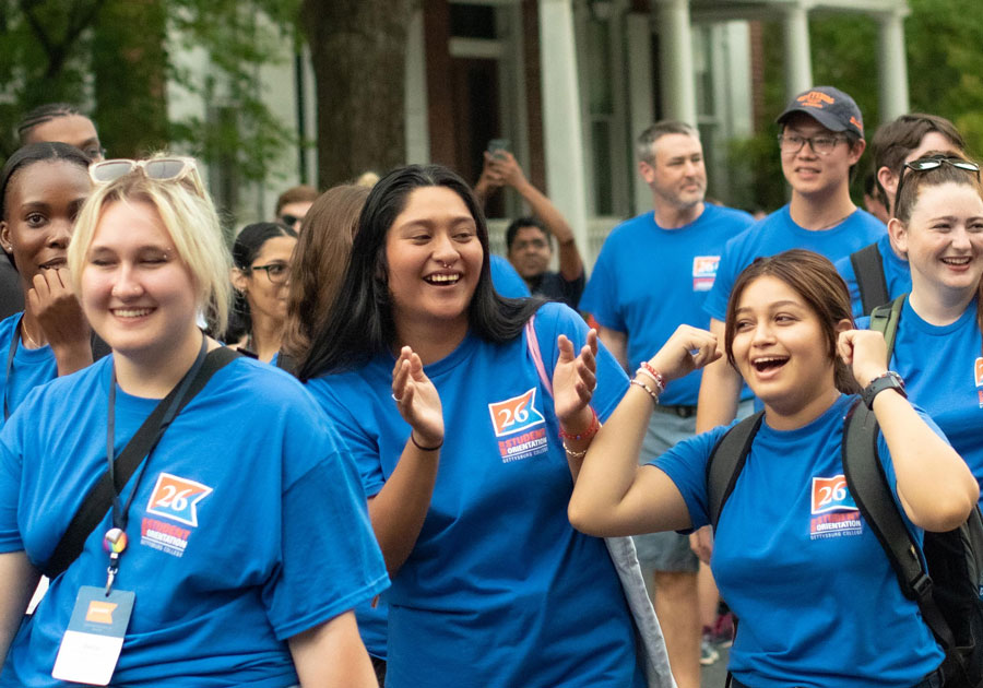 Students wearing blue shirts walking in the First Year Walk