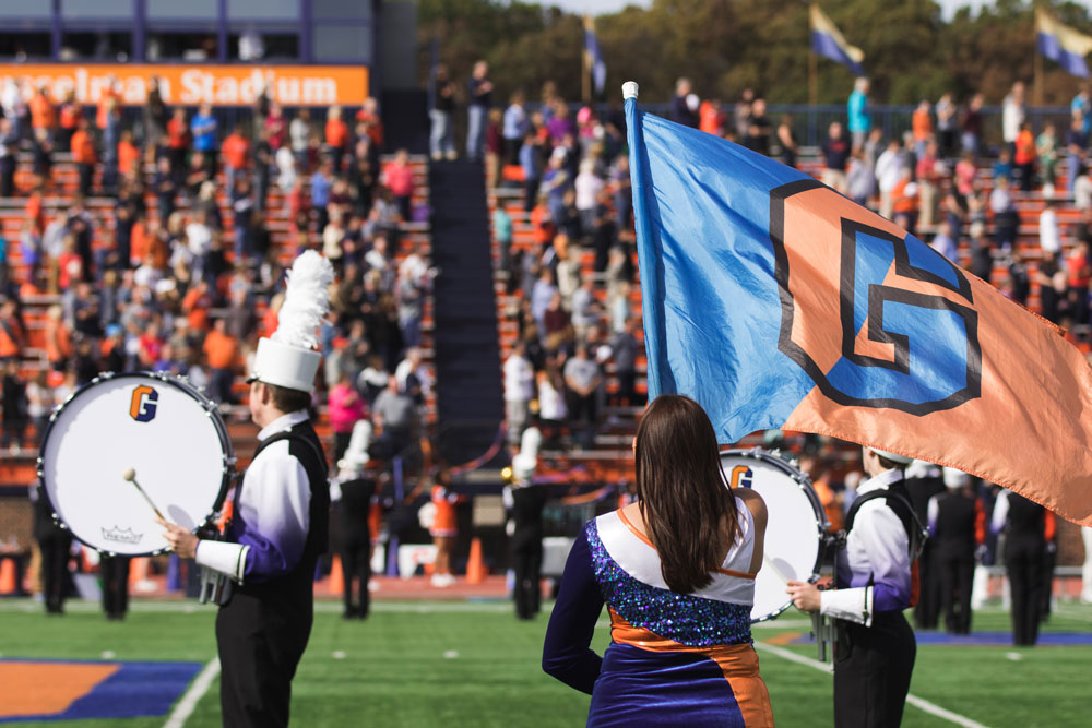 The Gettysburg College marching band performing in front of crowded bleachers