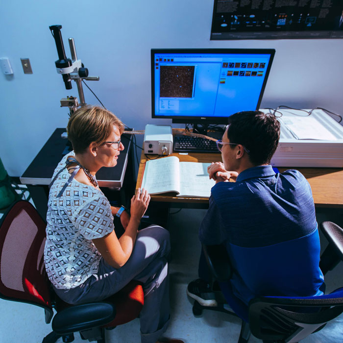 Student and teacher in a lab in front of a computer