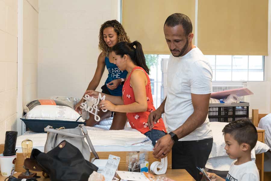 Student with parents inside a dorm room on Move-In Day