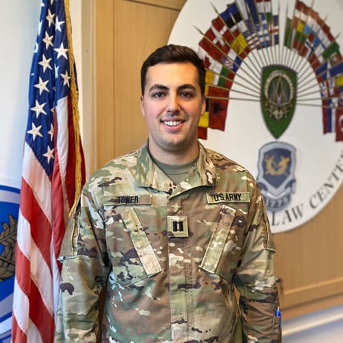 Brandon Tower in military uniform next to American flag