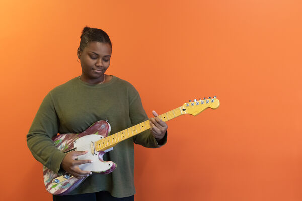 Lamara White holding a 3d printed guitar she made in the Innovation and Creativity Lab