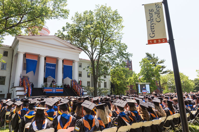 Graduates seated at Commencement facing Beachem Portico