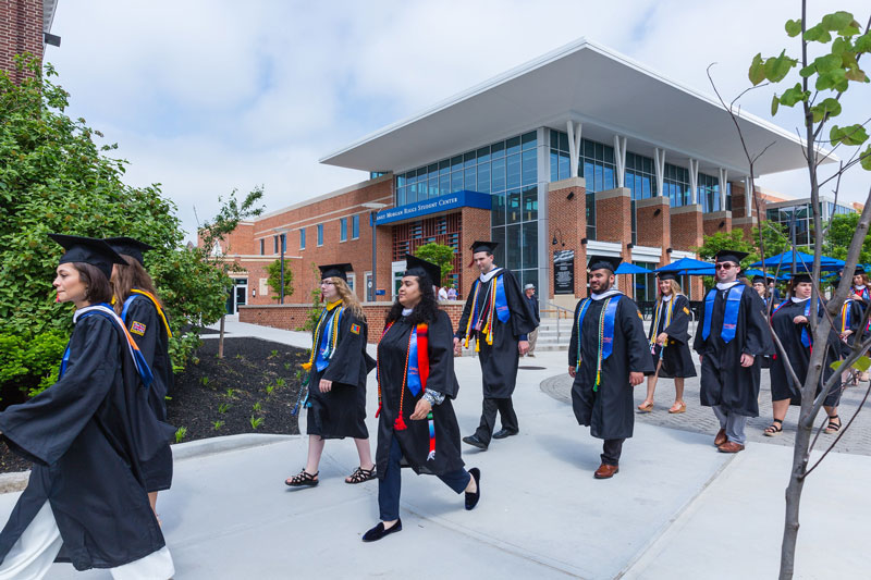 The graduate procession passing the Janet Morgan Riggs Center