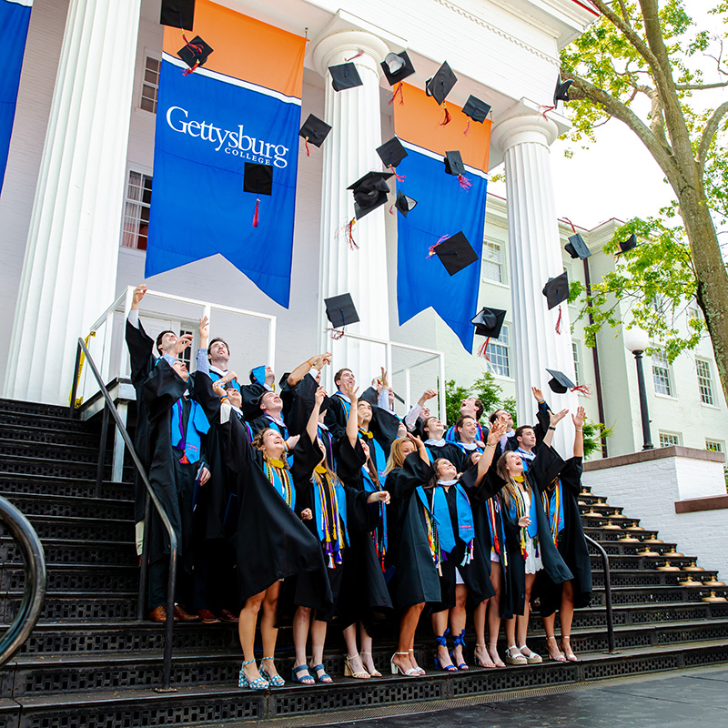 Lacrosse seniors throwing their graduation caps in the air