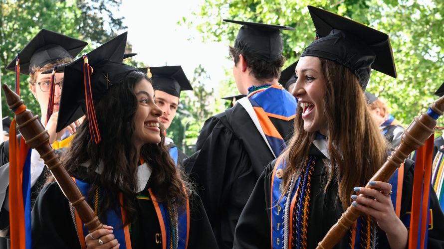 A picture of two graduates smiling at each other