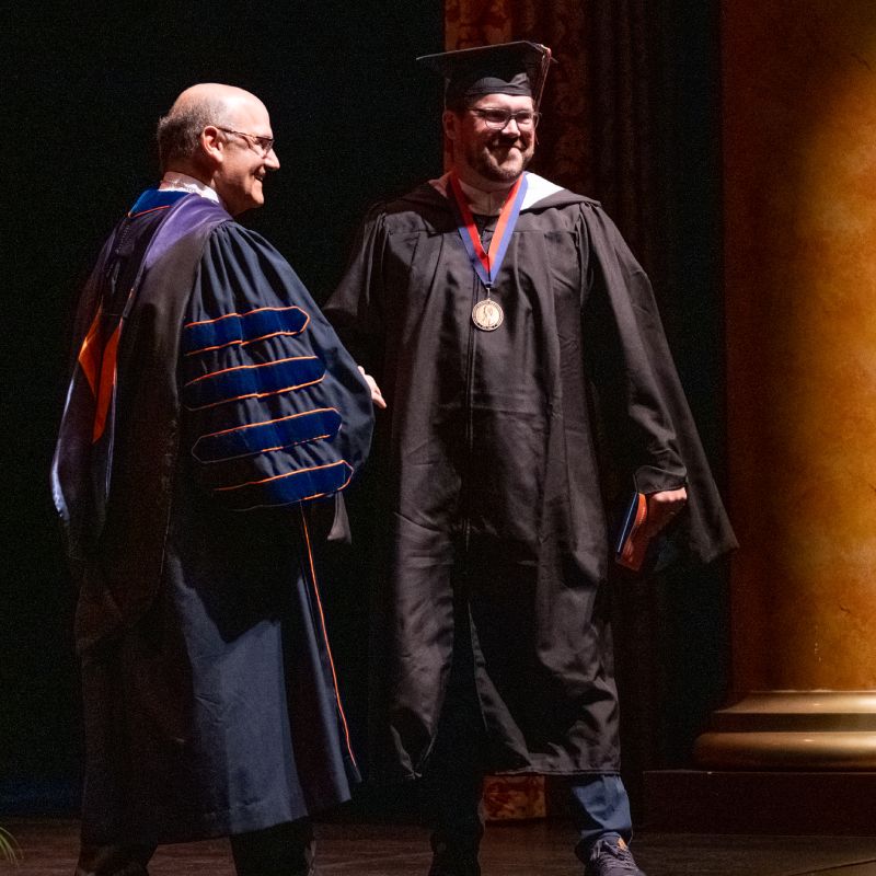 Graduate Shaking hands with the President Bob Iuliano