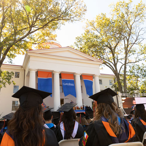 Graduates seated with Penn Hall in the background