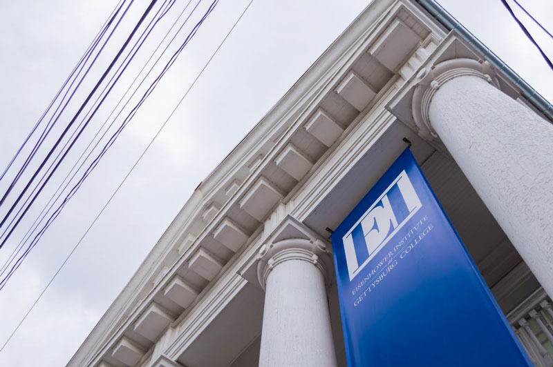 Photo of EI logo on a banner hanging from the front of the Eisenhower Institute building