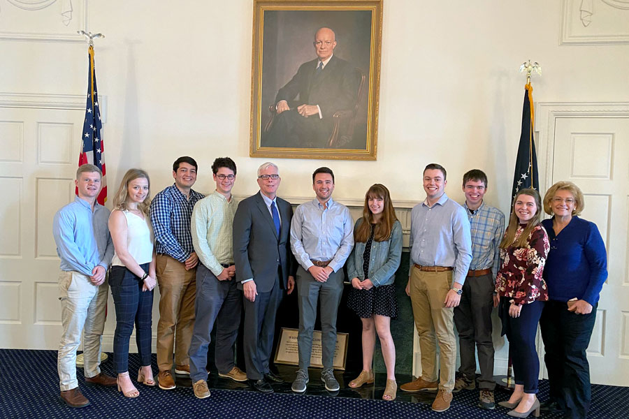 Fielding Fellows inside a room with a painting of Dwight Eisenhower