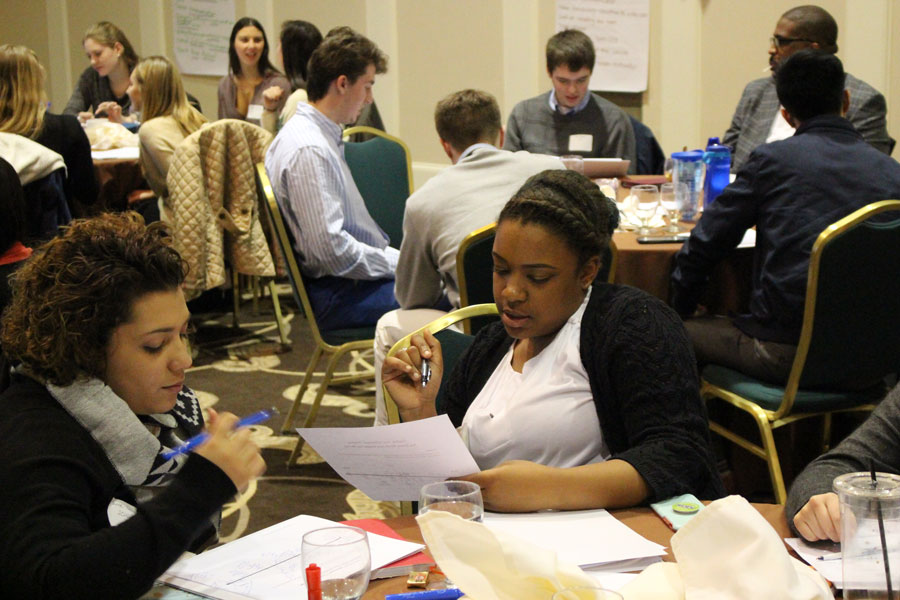 Students sitting at round tables at a professional event