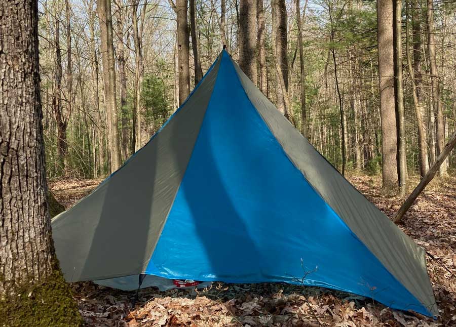 Blue tent outdoors in a wooded area
