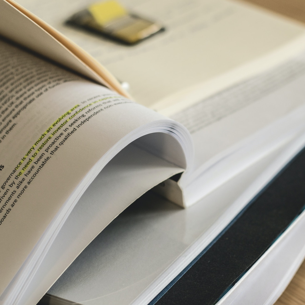 Stack of open books with post-it notes
