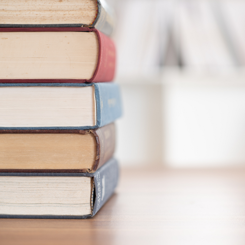 A photo of a stack of books with a blurred background.