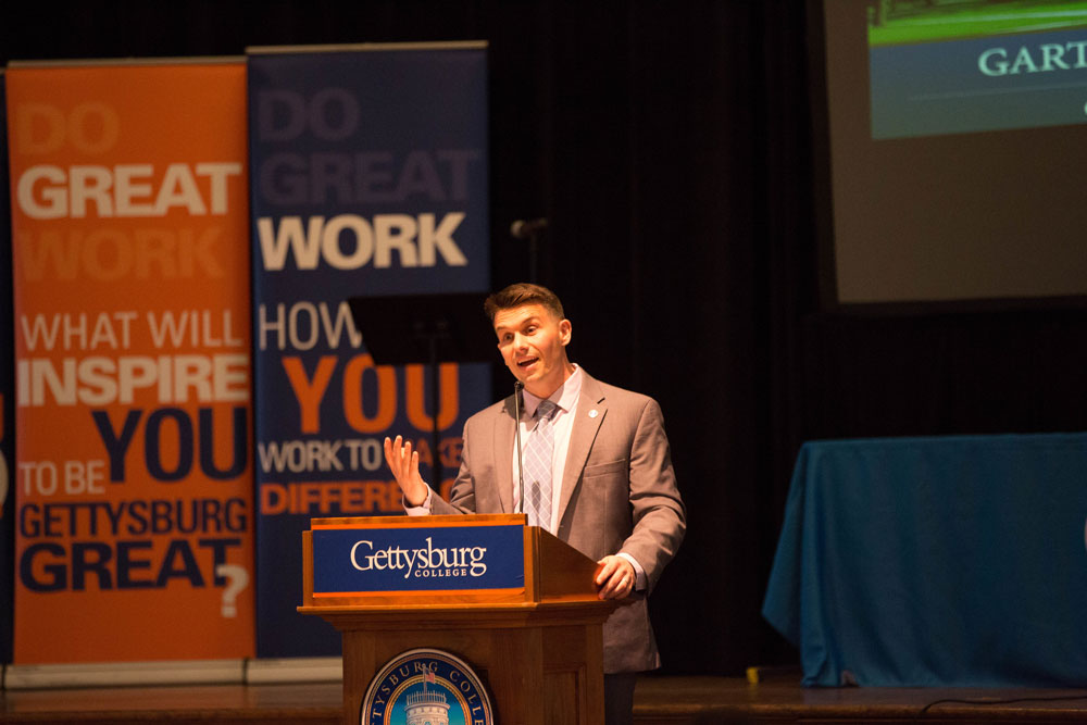 Andy Hughes speaking at a podium