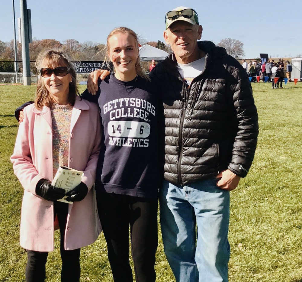 Amy Cantrell posing for a photo with her parents at a race