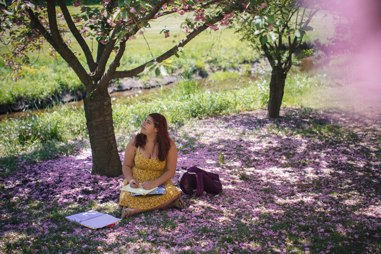 Candice Montenegro ’20 sitting on green and purple grass