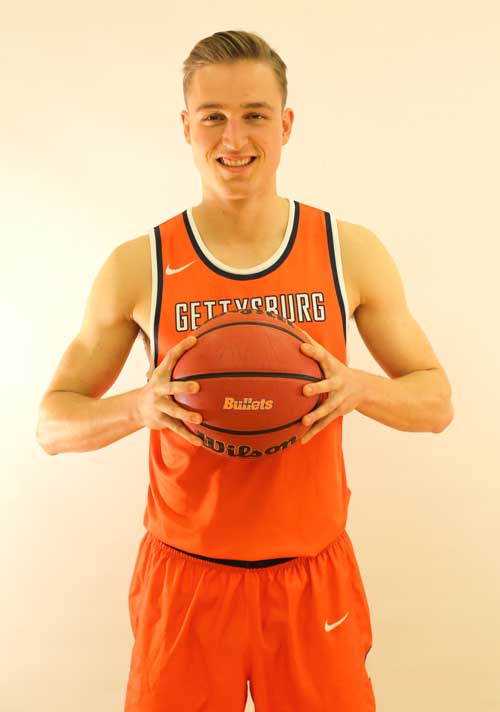 Chris Jack wearing Gettysburg College's basetball uniform holding a basketball